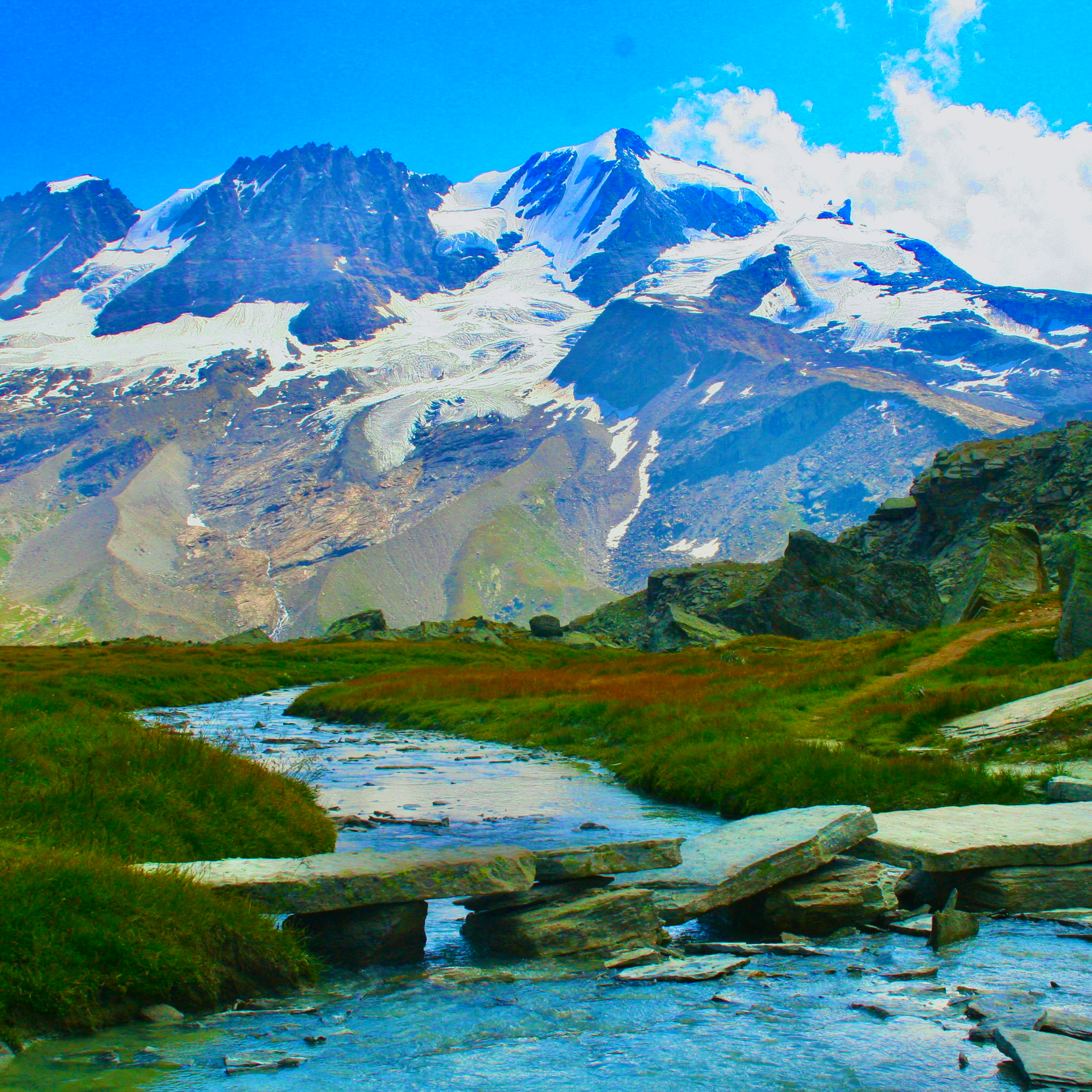 The Alta Via trail crossing ancient stone bridge acroos stream